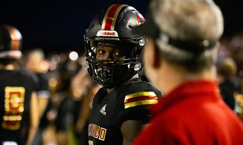 A football player looks at his coach on the sidelines